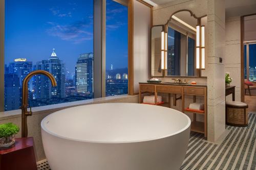 厦门厦门安达仕酒店（迷你吧免费&近万象城）的带浴缸的浴室,享有城市美景。