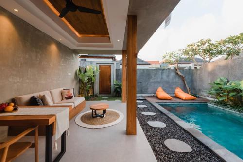 乌布Madara Ubud Villas的客厅设有游泳池、沙发和桌子