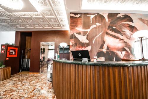 利多迪耶索罗苏维尼尔酒店的大堂设有酒吧,墙上挂有笔记本电脑