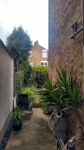 伦敦Homey, warm & welcoming room.的砖楼前种有植物的庭院