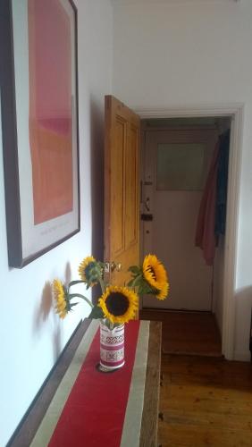 伦敦Homey, warm & welcoming room.的花瓶里满是向日葵坐在桌子上