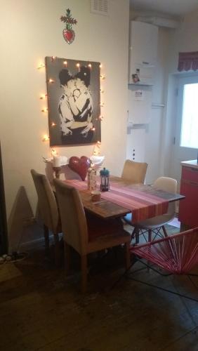 伦敦Homey, warm & welcoming room.的餐桌、椅子和墙上的绘画