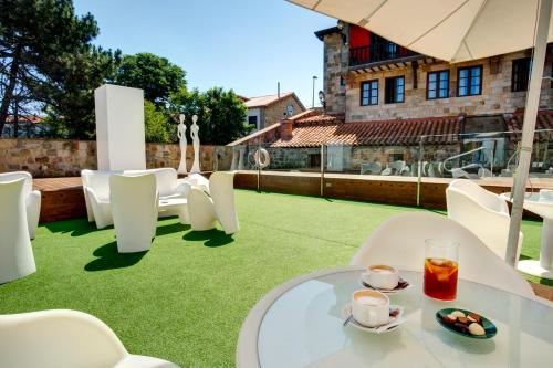 苏安塞斯哥斯达黎加埃斯梅拉达套房酒店的庭院配有白色的椅子和一张桌子,并备有饮料