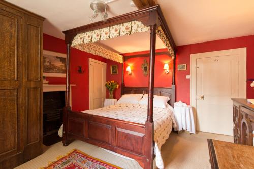 佩恩斯威克St Annes Bed and Breakfast的一间卧室配有一张带红色墙壁的天蓬床