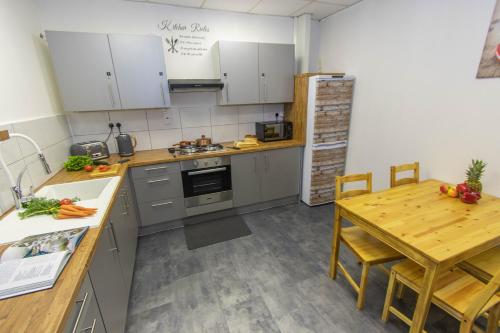伍尔弗汉普顿CADeS accommodation的厨房配有木桌、桌子、桌子和木桌。