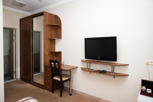 基辅波斯宫殿酒店的客房设有电视和带椅子的书桌。