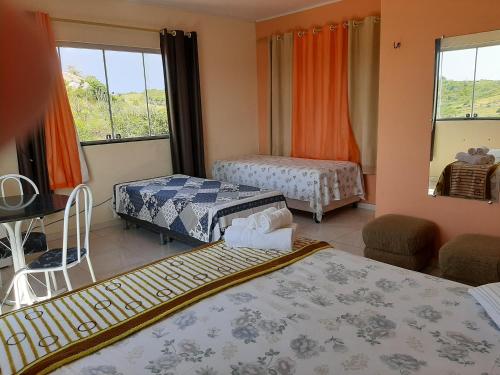 蒙蒂达斯加梅莱拉斯Sobre as Pedras Chalés的酒店客房设有两张床和窗户。