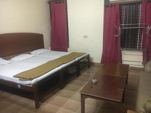 科钦Anupam Residency的一间卧室配有一张床和一张茶几