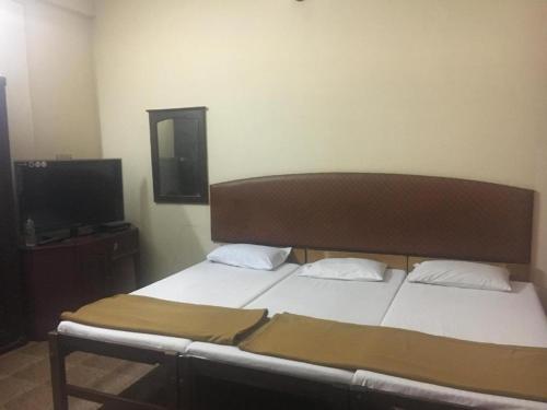 科钦Anupam Residency的一间卧室配有一张床和一台平面电视