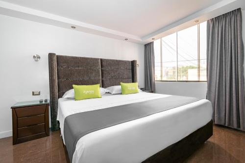 利马Ayenda Casa Aika的卧室配有一张带两个绿色枕头的大型白色床