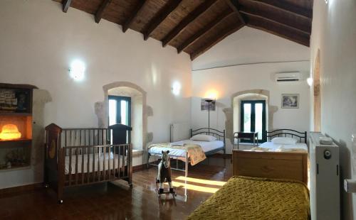 加瓦洛霍里翁Evaggelias Home Gavalochori的一间卧室配有两张床和一张婴儿床。