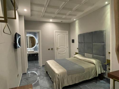 夸利亚诺Ninfa hotel的一间卧室配有一张大床和镜子