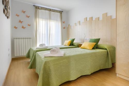 哈卡OTAL URBAN de "Casa Otal"的一间卧室配有两张带绿色和黄色枕头的床