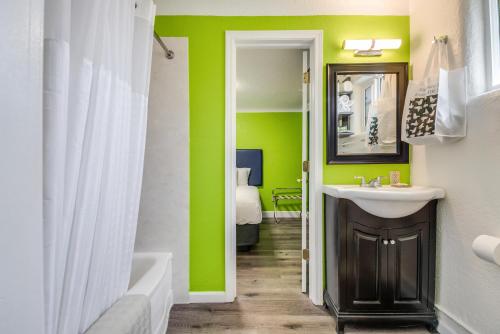 尤金Signature Inn Eugene的一间带水槽和绿色墙壁的浴室