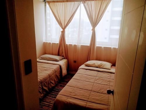 维纳德马Viña del mar descanso y entretención的带窗户的客房内的两张床