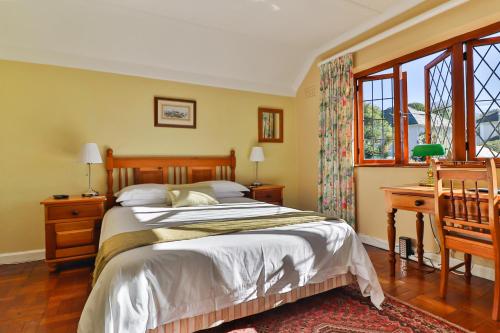 开普敦奈茨布雷旅馆的卧室配有一张床、一张书桌和窗户。