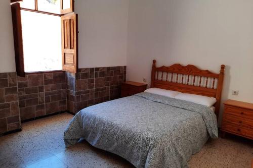 圣巴托洛梅Casa Rural Los Cipreses. Cercados de Araña的一间卧室设有一张床和一个窗口