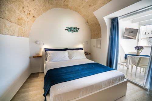 滨海波利尼亚诺Vico Blu的一间卧室,卧室内配有一张大床