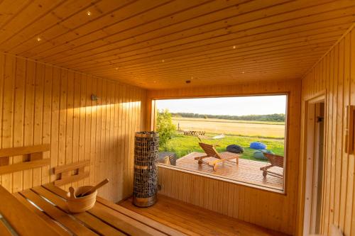 蒂萨菲赖德Natura Apartman Tiszafüred的小木屋内带大窗户的木制客房