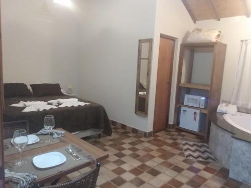 蒙特韦尔迪Chalés Recanto Vista do Valle的客房设有床、桌子和水槽