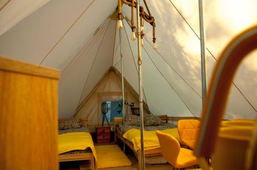 JankowiceGlamping z alpakami的一间设有帐篷的客房,里面配有床铺