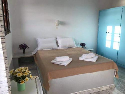 伊奥斯乔拉赫利俄斯旅馆的一间卧室配有一张大床和毛巾