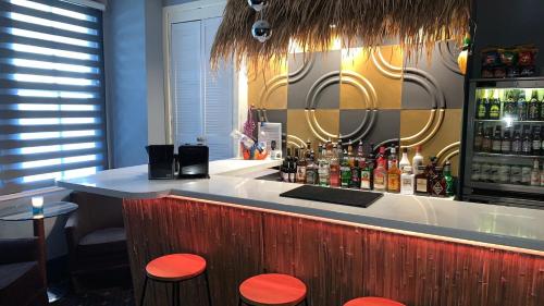 布莱克浦Tropics Beach Hotel的一间酒吧,在房间里摆放着橙色凳子