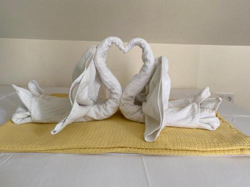 奥米沙利Apartments Michael & Petra , Omisalj, Insel Krk, Kroatien的两条毛巾放好,看起来像天鹅在床上