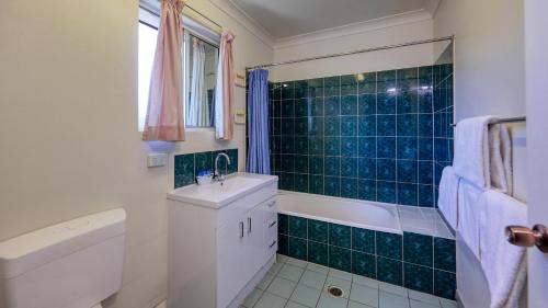 伊萨山镇景汽车旅馆的一间带水槽、浴缸和卫生间的浴室