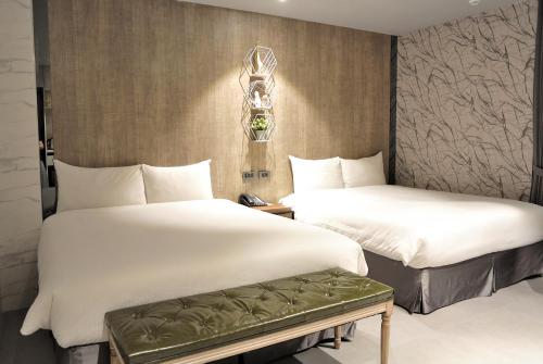 台中市逢甲K行旅（久窝旅店）的配有白色床单的酒店客房内的两张床