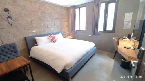 礁溪沐谷親子溫泉會館的一间卧室配有一张带彩旗枕头的床