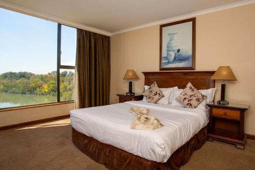 弗里尼欣Riviera on Vaal Resort的酒店客房,床上放着狗