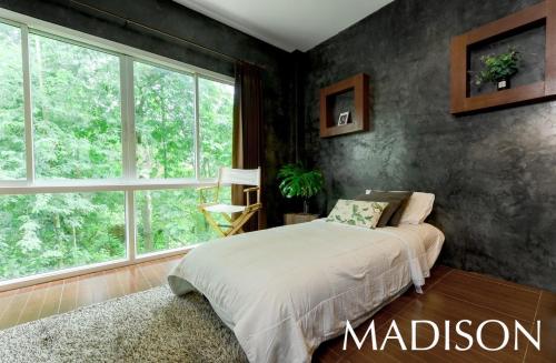 洛坤府Madison Hotel的一间卧室设有一张床和一个大窗户