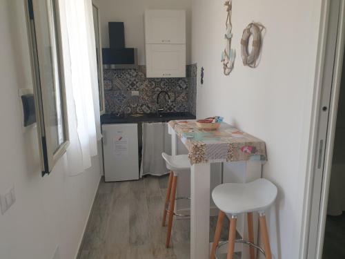 兰佩杜萨graziosa villetta III的一个带桌子和凳子的小厨房