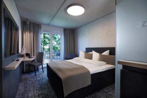 瓦尔堡Hotel Zeitgeist的配有一张床、一张书桌和一扇窗户的酒店客房