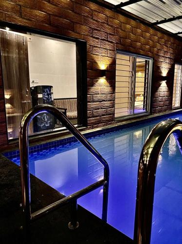 罗纳瓦拉Mount cottage supreme-ac-wifi-PVT POOL的一座拥有蓝色灯光的游泳池