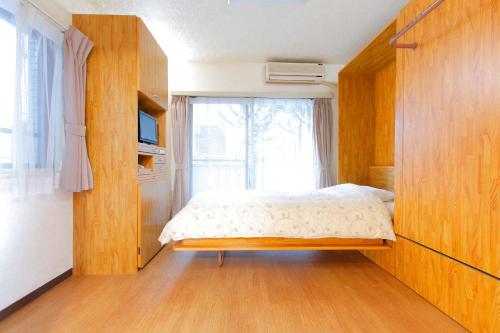 东京FLEXSTAY 中延旅馆的一间小卧室,配有床和窗户