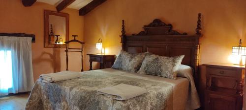 锡古恩萨Hotel Rural el Arrabal Siguenza的一间卧室配有一张大床和两条毛巾