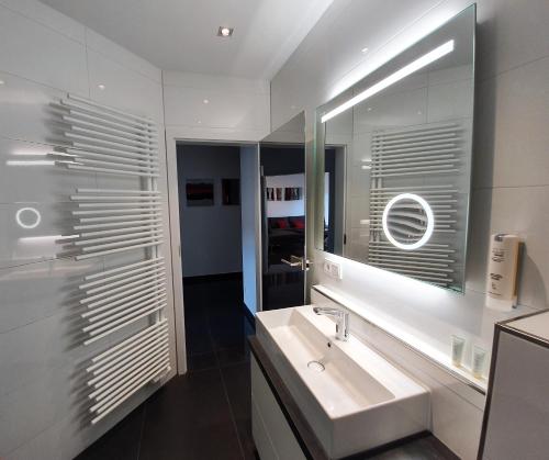 巴特克罗伊茨纳赫Ihr Ticket ins Grüne - Topmoderne 5-Sterne-Ferienwohnung的白色的浴室设有水槽和镜子