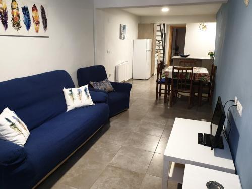 塞戈尔韦Casa Castillo de la Estrella的一间带蓝色沙发的客厅和一间厨房