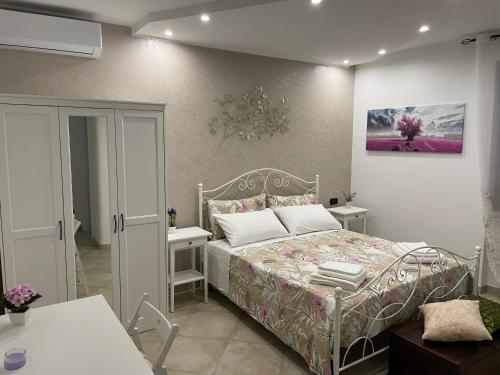 普蒂尼亚诺casa Belcolle的一间卧室配有床和两张白色桌子
