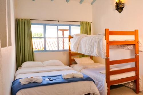 莱瓦镇Laureles de la Villa的一间卧室设有三张双层床和梯子