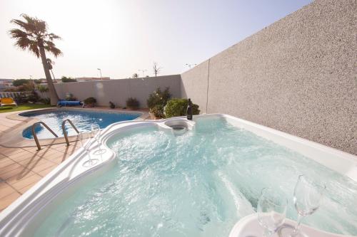厄尔梅达诺MEDANO4YOU Casa Girasol的一个带玻璃杯的热水浴池的游泳池