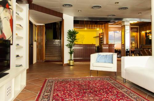 格拉多梅拉诺酒店的大堂配有白色椅子和地毯