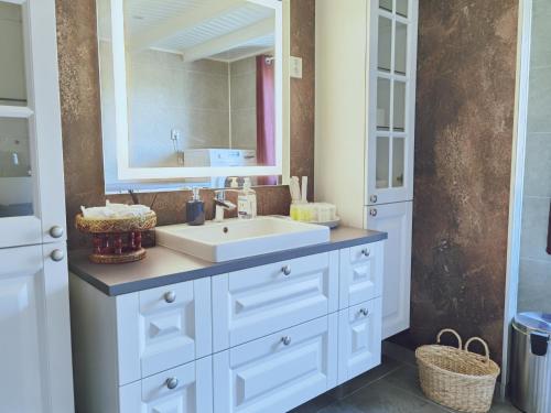 拉姆贝格BanPim Beachside Lofoten的浴室设有白色水槽和镜子