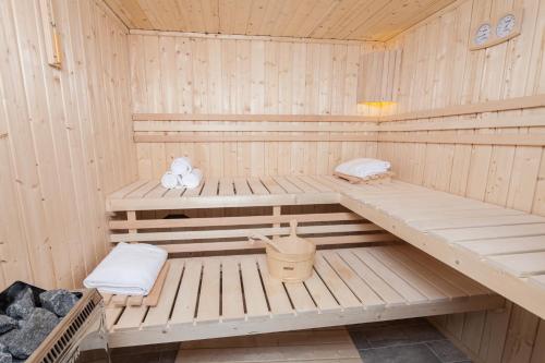 凯恩伊万瓦提娅Spa酒店和餐厅的木制桑拿浴室设有2个长椅和浴缸