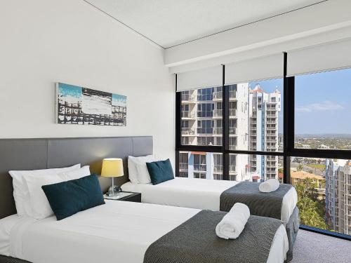 黄金海岸Hinterland Views 2BR apartment - Sierra Grand的酒店客房设有两张床和大窗户。