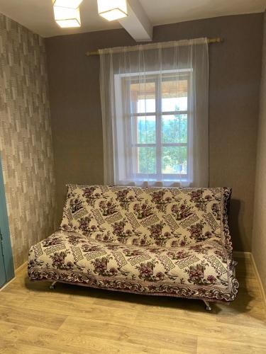 DmitrenkiСоколине Гніздо的窗户客房内的一张床位