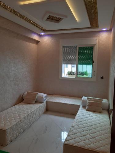 西迪布克纳德尔perle rare plage des Nations的客房设有两张床和窗户。