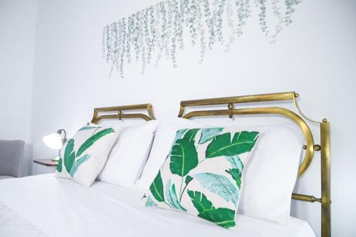 托尔基亚罗洛Villa Adele的一张带绿色和白色枕头的床